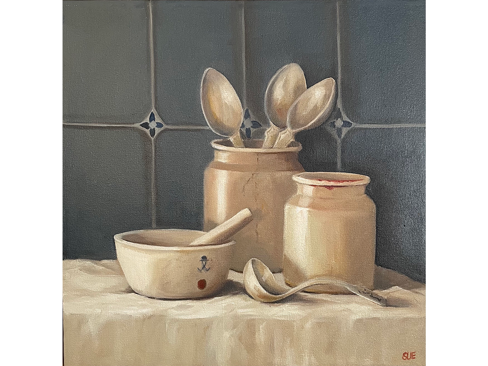 Square oil painting of rustic pottery jars, wooden spoons, a ceramic bowl, and a wooden ladle arranged on a cream cloth against a blue tiled backdrop.